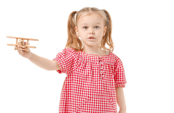 Nettes kleines Mädchen mit Spielzeugflugzeug auf weißem Hintergrund - Foto, Bild