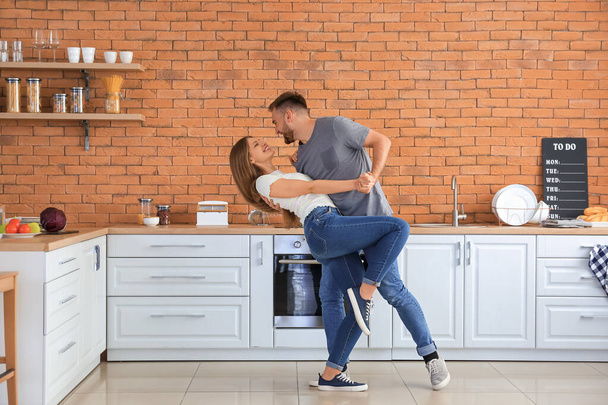 Happy young couple dancing in kitchen - Fotoğraf, Görsel