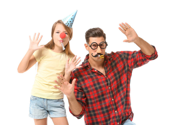 Отец и дочь в смешной маскировке и со свистками на белом фоне. Празднование Дня дураков
 - Фото, изображение