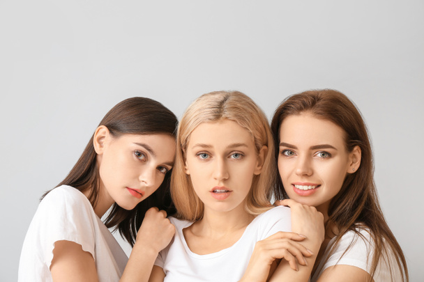 Jovens mulheres com bela maquiagem no fundo claro
 - Foto, Imagem