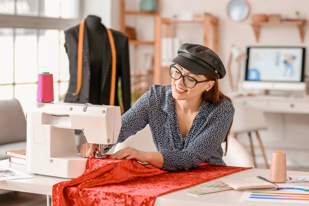 Jovem mulher costura roupas no atelier
 - Foto, Imagem