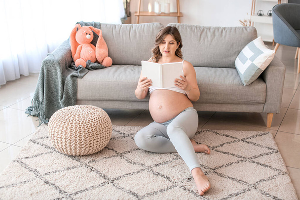 Schöne schwangere Frau liest Buch zu Hause - Foto, Bild