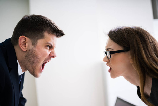 Side View Of Business People Quarreling At Desk In Office - 写真・画像