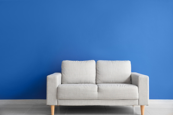 Сучасний диван біля кольорової стіни
 - Фото, зображення