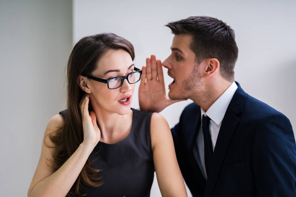 Close-up Of Businessman Whispering Into Female Partner's Ear - Фото, зображення
