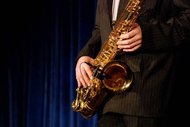 young man playing saxophone in studio - Foto, afbeelding