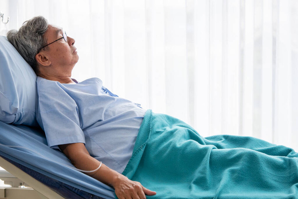 asiático paciente hombre acostado en hospital cama en el hospital habitación
. - Foto, Imagen