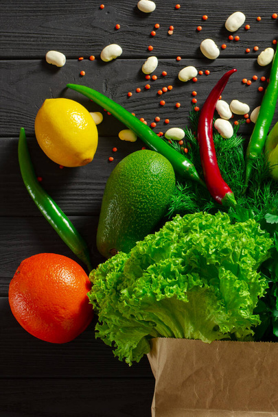 Plantaardige voedselset van veelkleurig voedsel voor gezond eten ligt op een zwarte houten tafel - Foto, afbeelding