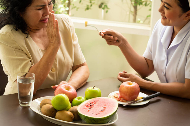 Dospělá pacientka odmítá jablko od zdravotní sestry. - Fotografie, Obrázek