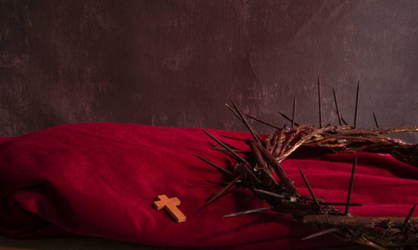 Crown of thorns of Jesus Christ with a small cross on a red cloth - Photo, Image