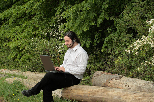 Man works with laptop in the wild - Foto, imagen