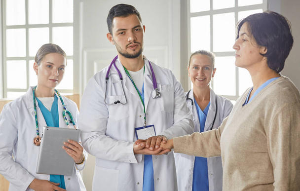 Patient with a group of doctors at the background - Photo, Image