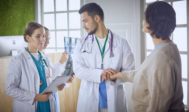 patiënt met een groep van artsen op de achtergrond - Foto, afbeelding