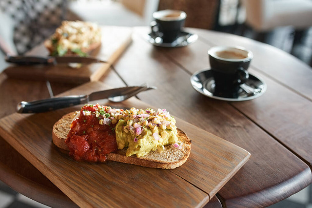 Single piece of italian baguette with cheese pasta toppings and red tomato sauce served with coffee in cafe - Foto, imagen