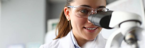 Medicine worker looking through microscope - Photo, Image