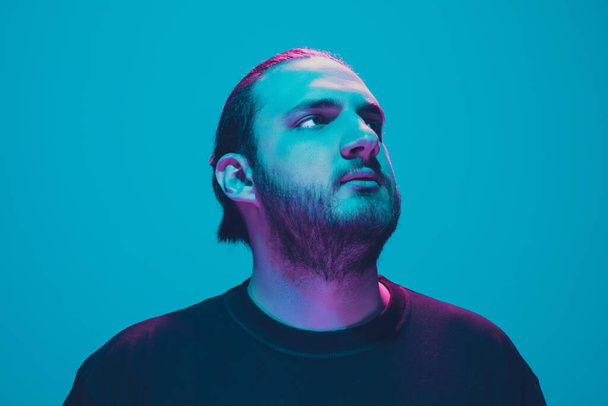 Portrait of a guy with colorful neon light on blue background - cyberpunk concept - Fotografie, Obrázek