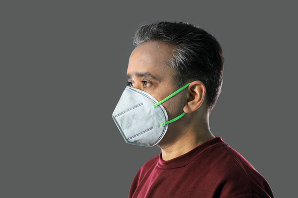 Indian Man wearing a N95 mask for protection against virus, dust, pollution and smog - Photo, Image