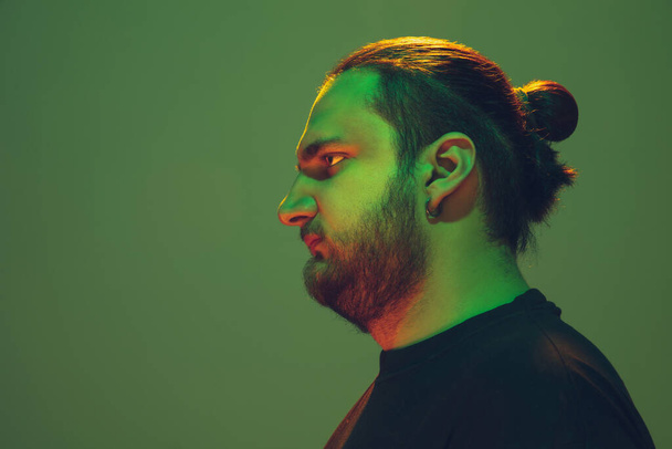 Portrait of a guy with colorful neon light on green background - cyberpunk concept - Foto, Imagen