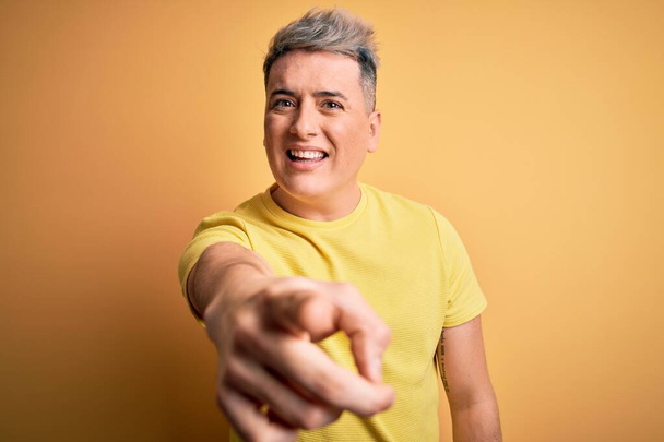 Junger gutaussehender moderner Mann in gelbem Hemd über gelbem isoliertem Hintergrund, der unzufrieden und frustriert in die Kamera zeigt, wütend und wütend auf dich - Foto, Bild