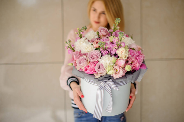 Beautiful large bouquet of pink flowers in a round box decorated with ribbons - Photo, Image