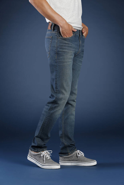 обрізаний вид людини, позує в джинсах в студії, концепція моди
  - Фото, зображення