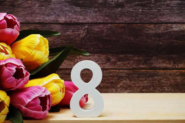 Women's day with 8 letter and tulip flowers bouquet with space copy on wooden background - Foto, Imagem