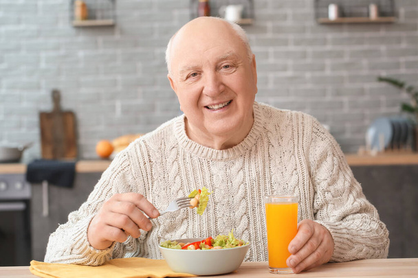 Porträt eines älteren Mannes beim Mittagessen zu Hause - Foto, Bild