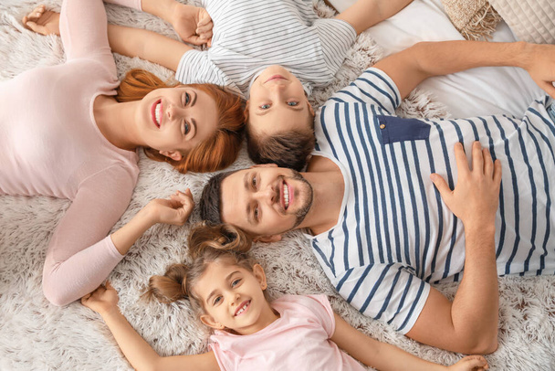 Happy family lying on bed at home - Zdjęcie, obraz