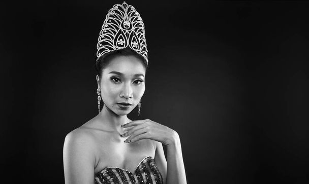 黒と白の肖像画のミスペガント美コンテストでスパンコールイブニングボールガウン付きロングドレスダイヤモンドクラウン、アジアの女性のファッションは、ヘアスタイル、スタジオ照明暗い背景劇的な構成 - 写真・画像
