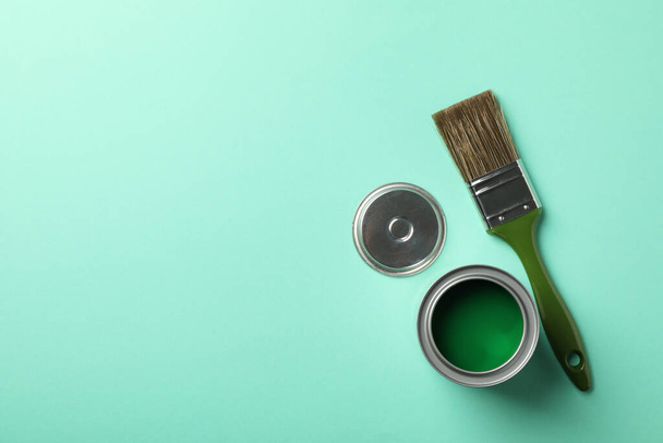 Paint can and brush on green background, top view - Foto, Bild