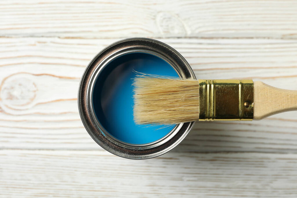 Paint can and brush on wooden background, top view - Foto, imagen