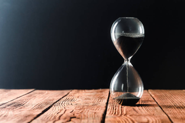 Modern hourglass on wooden background. creative photo. - Foto, imagen