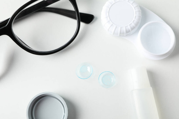 Glasses, contact lenses, liquid and case on white background, top view - Φωτογραφία, εικόνα