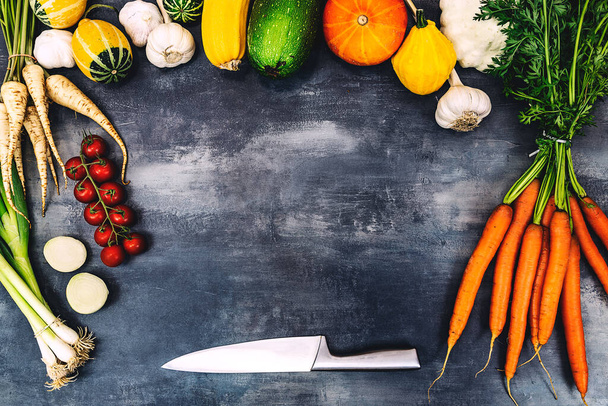 Овощи с ножом на сером фоне. Подготовка здорового питания
. - Фото, изображение