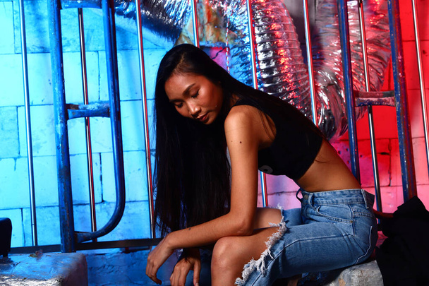Gyönyörű ázsiai építész mérnök nő Hosszú egyenes fekete haj, hatalmas karcolás farmer nadrág, koncepció nő tehet High Fashion Post az építési területen Red Blue hátterek - Fotó, kép