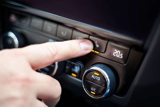 Ręczne naciśnięcie przycisku do podgrzewanych siedzeń w samochodzie - Zdjęcie, obraz