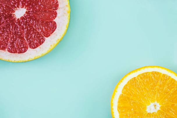 Grapefruit mit Orange in den Ecken auf zyanischem Hintergrund - Foto, Bild