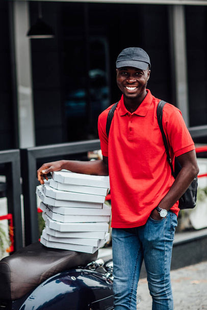 Portrait of happy man works on scooter, conveys fast food from restaurant for customers. Take your order. - Foto, Bild