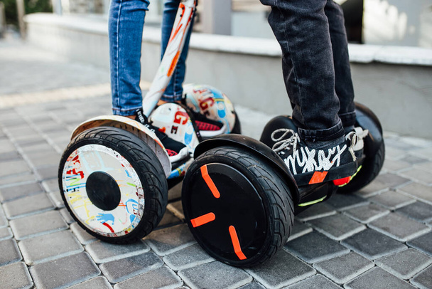 Couple legs riding electric mini hoverboard in park. Close up leg photo. - Foto, Imagen