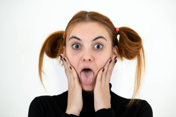 Detailní portrét legrační zrzka dospívající dívka s dětským účesem vyčnívat její jazyk izolované na bílém pozadí. - Fotografie, Obrázek