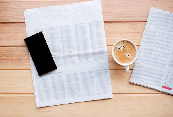 φλιτζάνι καφέ με εφημερίδα και smartphone σε καφενείο.  - Φωτογραφία, εικόνα