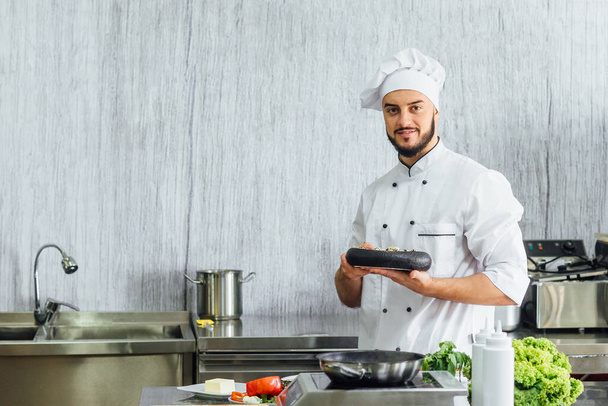 Ritratto dello chef nella cucina del ristorante con uova preparate pronte, piatto sulle mani. - Foto, immagini
