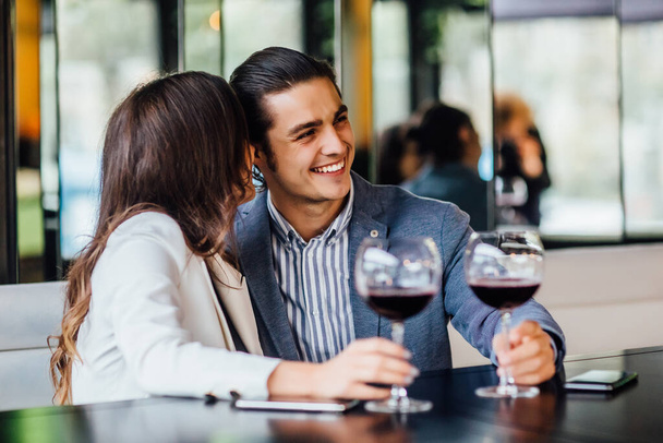 Romantic young couple enjoying dinner at cafe, relationship and romantic time, happy celebrating and making cheers with glasses of red wine. - 写真・画像