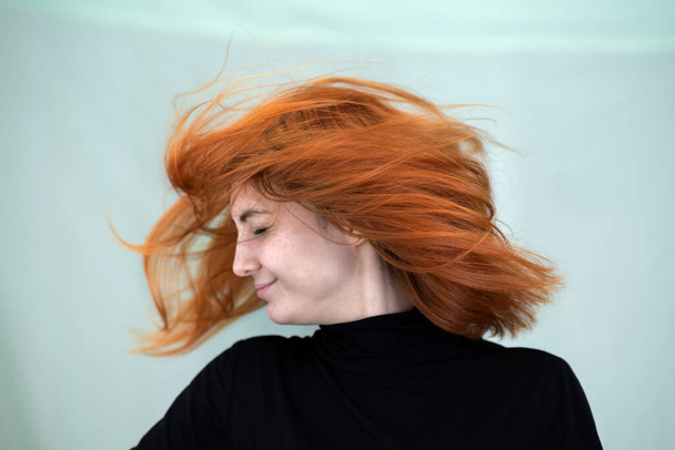 Close up portret van mooie roodharige meisje met lange golvende haren waait op de wind. - Foto, afbeelding