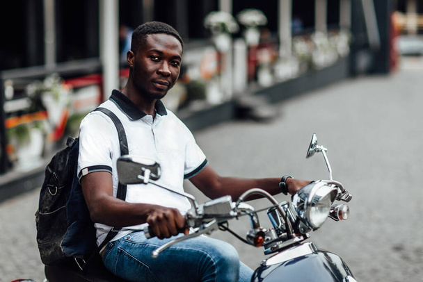Skip classes. Appealing male student sitting on motorbike in street. - Foto, Bild