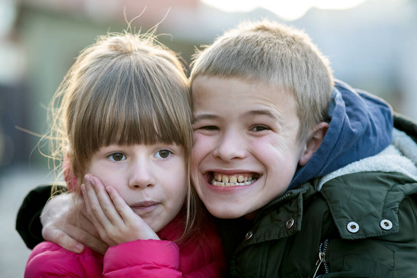Dva děti chlapec a dívka blbnout kolem baví spolu venku za slunečného podzimního dne. Šťastné dětství koncept. - Fotografie, Obrázek
