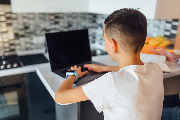 Jeune enfant regardant l'écran pc faire des achats en ligne à la maison
. - Photo, image
