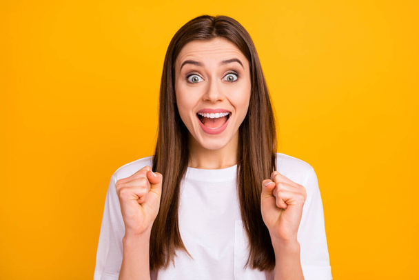 Closeup photo of crazy pretty lady long perfect hairstyle listen amazing news open mouth raise fists celebrate lottery win wear casual white t-shirt isolated vivid yellow color background - Foto, Imagem