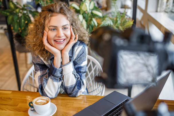 Porträt einer lächelnden Bloggerin in Freizeitkleidung mit einer Tasse Kaffee. - Foto, Bild