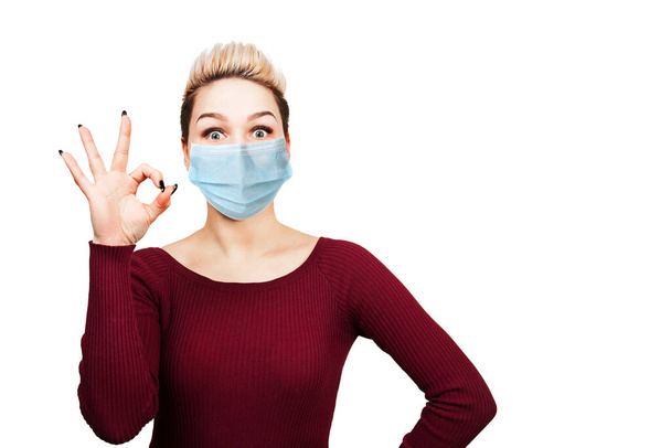 young woman sign ok, wearing protective face mask prevent virus infection, pollution, white isolated background. - Фото, зображення